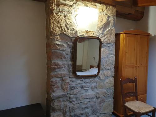 a mirror on the side of a stone wall at Masia l`Arà in La Baronia de Rialb