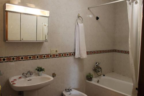 y baño con lavabo, aseo, bañera y espejo. en Apartamentos Rurales Rosendo: El Tomillo, en Capileira