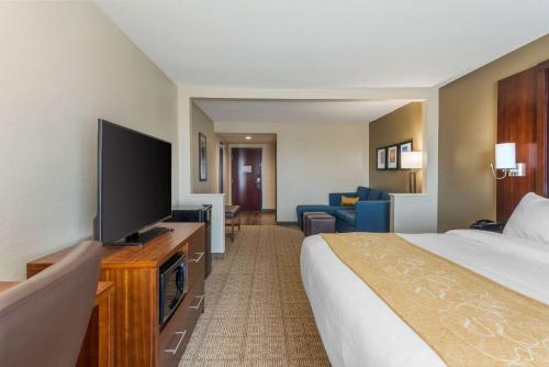 a hotel room with a bed and a flat screen tv at Comfort Inn & Suites in Big Spring