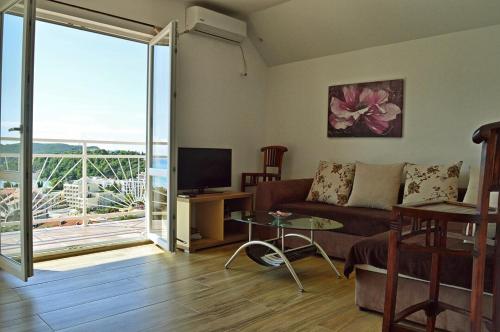 a living room with a couch and a television at Apartments Nikčević in Budva