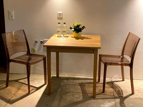 a wooden table with two chairs and a vase of flowers at B&B tannen124 in Oberburg