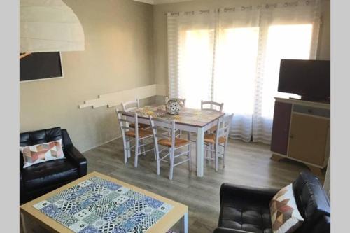 un salon avec une table, des chaises et un canapé dans l'établissement Maison familiale à Nîmes, à Nîmes