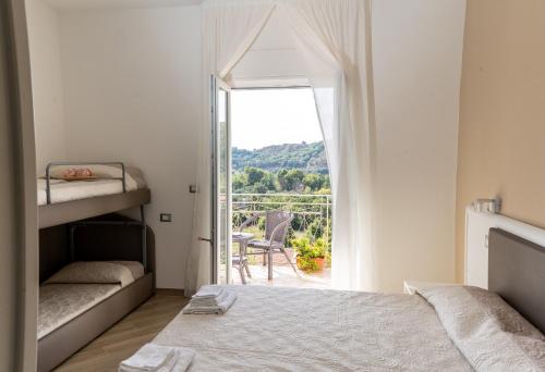 a bedroom with a bed and a balcony with a view at Blu Palinuro in Palinuro