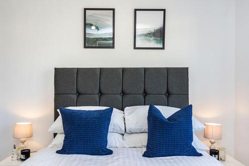 a bedroom with a bed with blue and white pillows at Cozy 3 Bedroom House in Aveley, Thurrock in Aveley