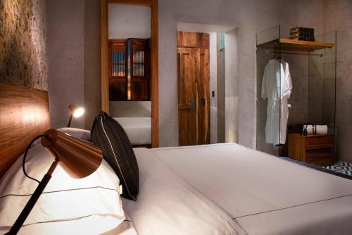 a bedroom with a bed in a room with a closet at Diez Diez Collection in Mérida