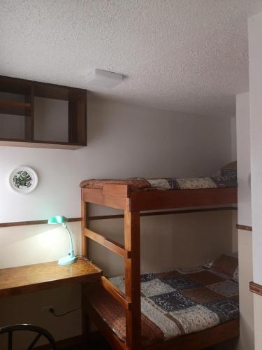 a room with two bunk beds and a desk at Apartamento 11 Tec in Cartago