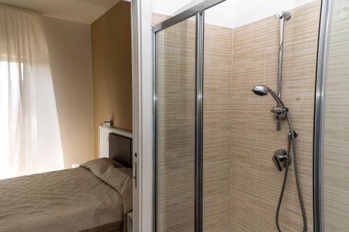 a shower with a glass door in a bedroom at Blu Palinuro in Palinuro
