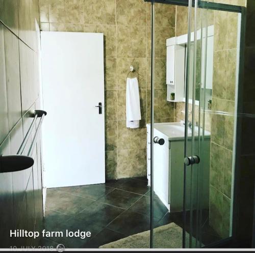 a bathroom with a shower and a glass door at Hill Top Farm Lodge in Sea Park