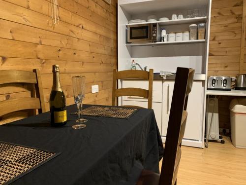a table with a bottle of wine and a glass at Southernwood - Family Lodge in Didcot