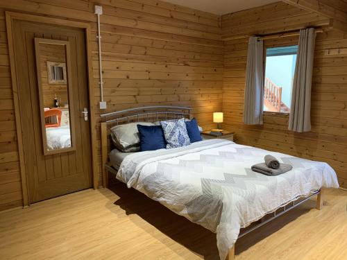 um quarto com uma cama num quarto de madeira em Southernwood - Garden Lodge 1 em Didcot