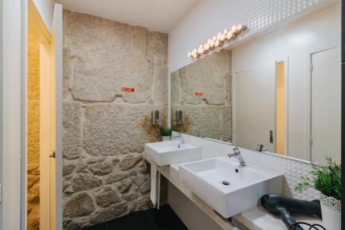 a bathroom with a sink, mirror, and bathtub at Happy Porto Hostel & Apartments in Porto