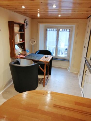 a living room with a wooden table and chairs at Studio CHAUDES AIGUES in Chaudes-Aigues