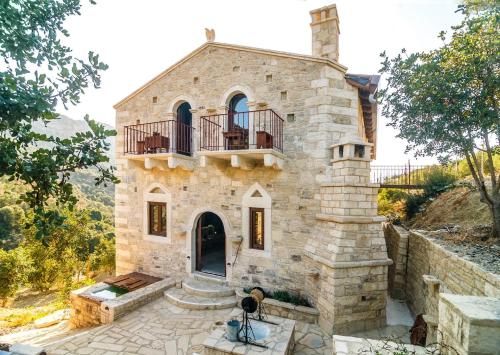 a stone house with a balcony on top of it at Kamihis Farm House Experience in Zaros