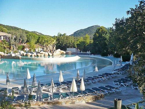 a pool with chairs and umbrellas in a resort at Les Bastides 30282 in Grimaud