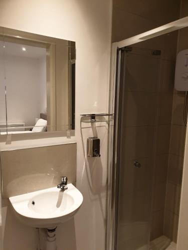a white bathroom with a sink and a shower at Modern Newgate Apartments - Convenient Location, Close to All Local Amenities in Stoke on Trent