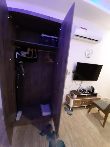 a room with a desk and a tv and a chair at Qasr Alshamal Hotel in Arar