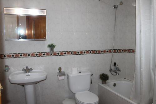 a bathroom with a toilet and a sink and a tub at Apartamentos Rurales Rosendo: El Jazmin in Capileira