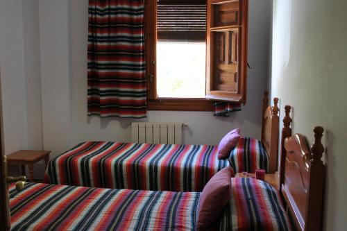 a bedroom with two beds and a window at Apartamentos Rurales Rosendo: El Jazmin in Capileira