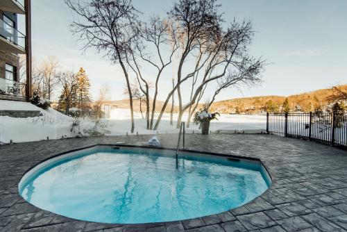 a swimming pool in the middle of a yard at Entourage sur-le-Lac in Lac-Beauport