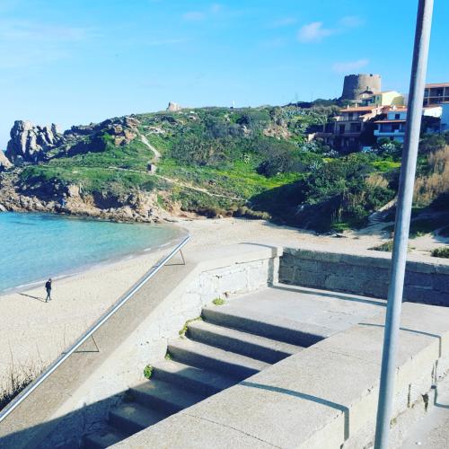 a person walking on the beach near the ocean at Studio S in Santa Teresa Gallura