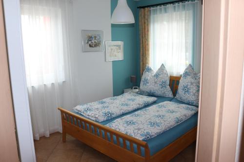 Schlafzimmer mit einem Bett mit blauer Bettwäsche und einem Fenster in der Unterkunft Kuschelige Ferienwohnung nahe Kronach in Kronach
