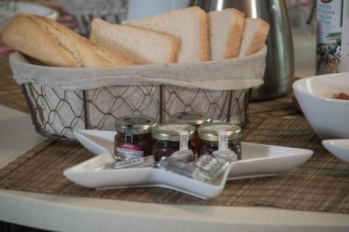 una cesta llena de pan y una cesta de mermelada en Posada del Herrero, en Madridejos
