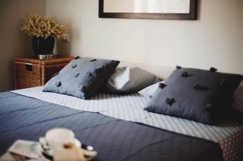 a teddy bear sitting on a bed with blue pillows at Casa Luna in Santa Maria di Castellabate
