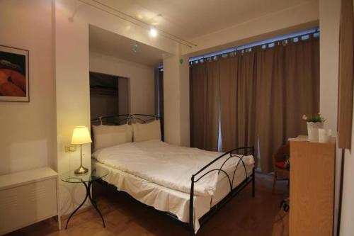 a bedroom with a bed and a table and a window at Park View Bucharest in Bucharest