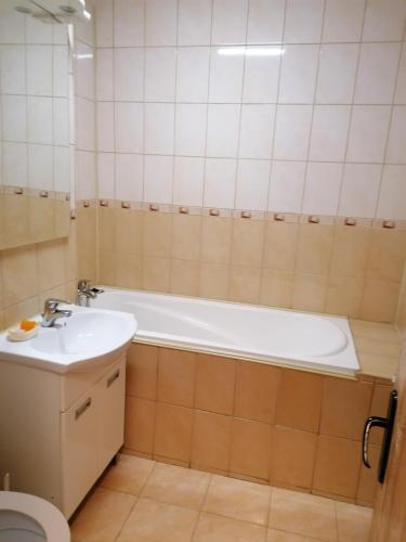 a bathroom with a tub and a sink and a toilet at Apartament 3 camere Zărnești Brasov in Zărneşti