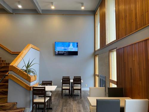 a waiting room with tables and a tv on a wall at Red Lion Inn & Suites Post Falls in Post Falls