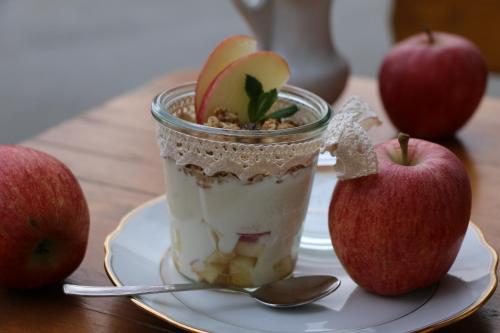 a cup of dessert on a plate with apples at Residence Kahn in Santa Maddalena in Casies