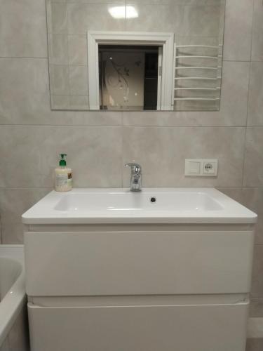 a white sink in a bathroom with a mirror at Апартаменти Люкс2 in Khmelʼnytsʼkyy