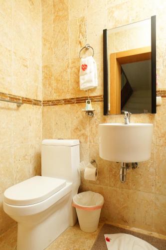 a bathroom with a toilet and a sink at Sybaris Suites & Residences in Juan Dolio