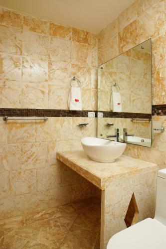 a bathroom with a sink and a mirror at Sybaris Suites & Residences in Juan Dolio