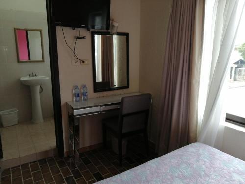 - une chambre avec un bureau, un lavabo et un miroir dans l'établissement Hotel Tamuin, à Antiguo Tamuín