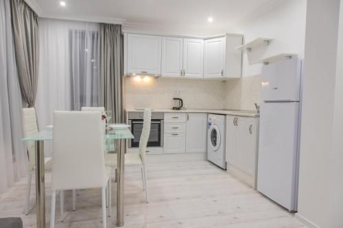 uma cozinha com electrodomésticos brancos e uma mesa e cadeiras em Vip Luxury APARTMENT em Burgas