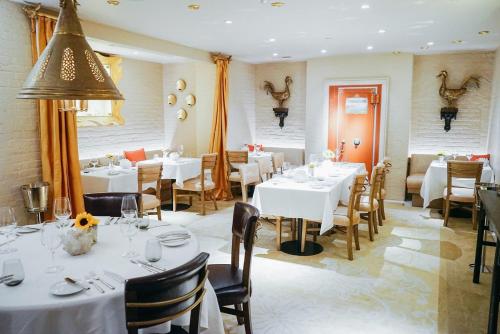 un comedor con mesas y sillas blancas en The Ivy Hotel, en Baltimore