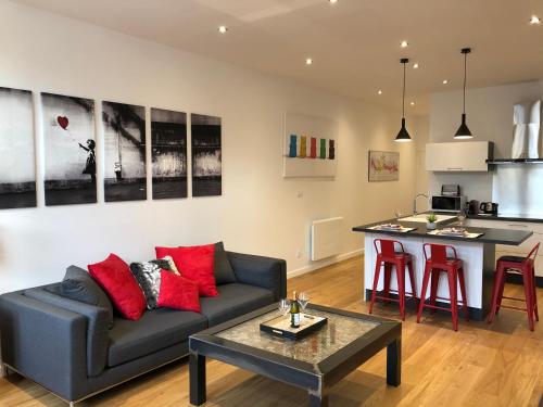 un salon avec un canapé et une table et une cuisine dans l'établissement La Renaissance au coeur du centre historique, à Beaune