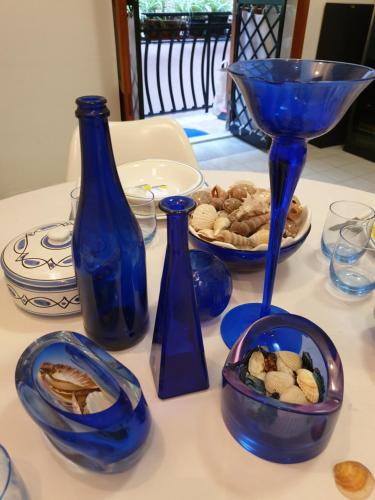 a table with blue vases and a plate of food at Casa Alessia in Aci Castello