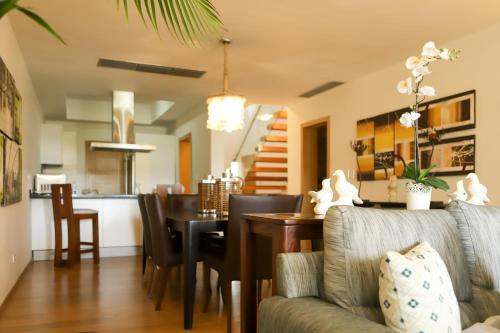 a living room with a table and a dining room at Sybaris Suites & Residences in Juan Dolio