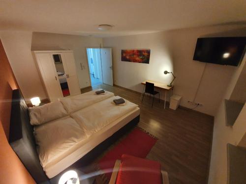 a bedroom with a large white bed and a desk at White Pearl Hostel 2 in Nuremberg