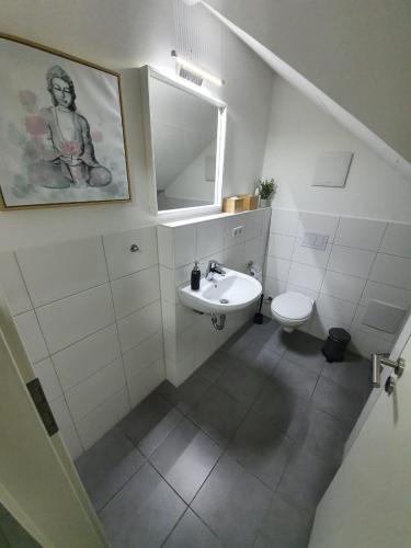 a white bathroom with a sink and a toilet at White Pearl Hostel 2 in Nürnberg