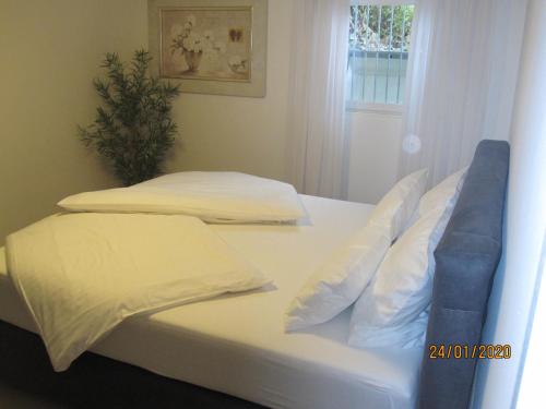 two beds with white sheets and pillows in a bedroom at Ferien- bzw. Zeitwohnen Burglengenfeld » Apartment 2 in Burglengenfeld