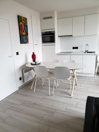 a kitchen with a table and chairs in a room at Appartement, residentie Syci in Koksijde