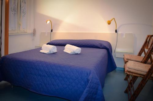 a blue bed with two white pillows on it at Acitrezza View in Aci Castello
