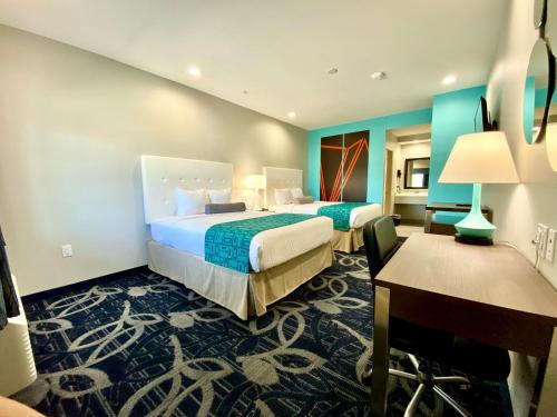 a hotel room with two beds and a desk at Americas Best Value Inn Houston Willowbrook in Houston
