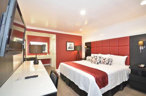 a hotel room with a bed with a red wall at Legend Hotel Hollywood in Los Angeles