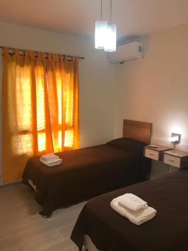 une chambre d'hôtel avec deux lits et une fenêtre dans l'établissement DEPARTAMENTO DE 2 DORMITORIOS C/ COCHERA, à Villa María