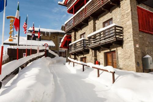 a snow covered building with flags in front of it at Hotel Biancaneve in Sestriere