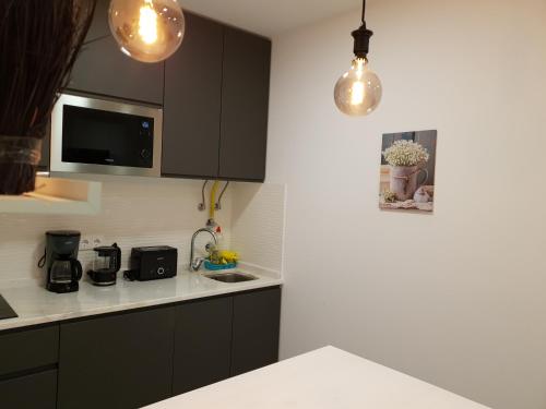 a kitchen with black cabinets and a white counter top at Beco's House - Suits in Ílhavo